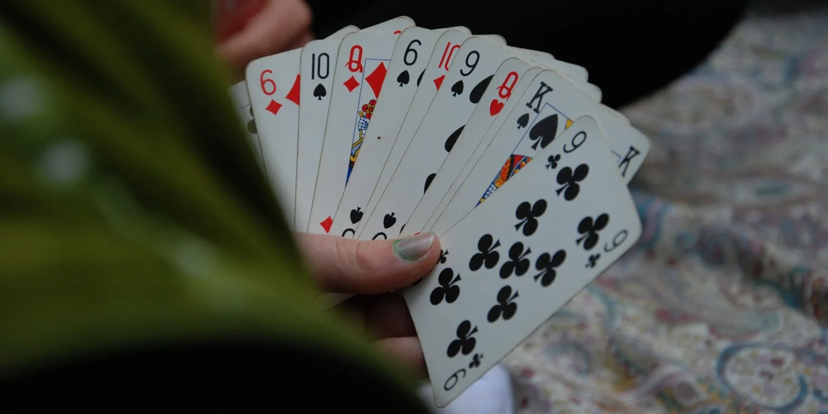 person holding fan of playing card in hand